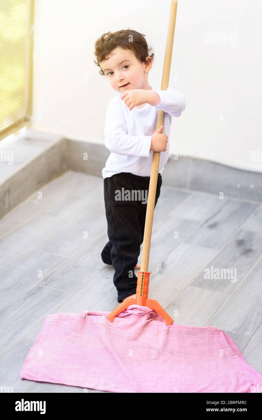 Portrait of little smiling boy cleaning floor at home Stock Photo Alamy