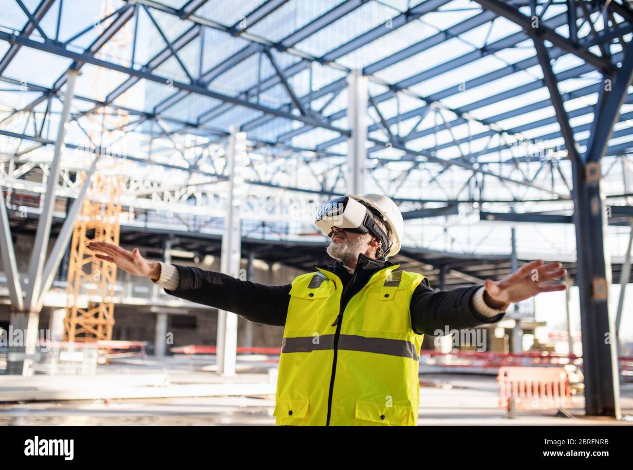 Man engineer using VR goggles on construction site. Stock Photo