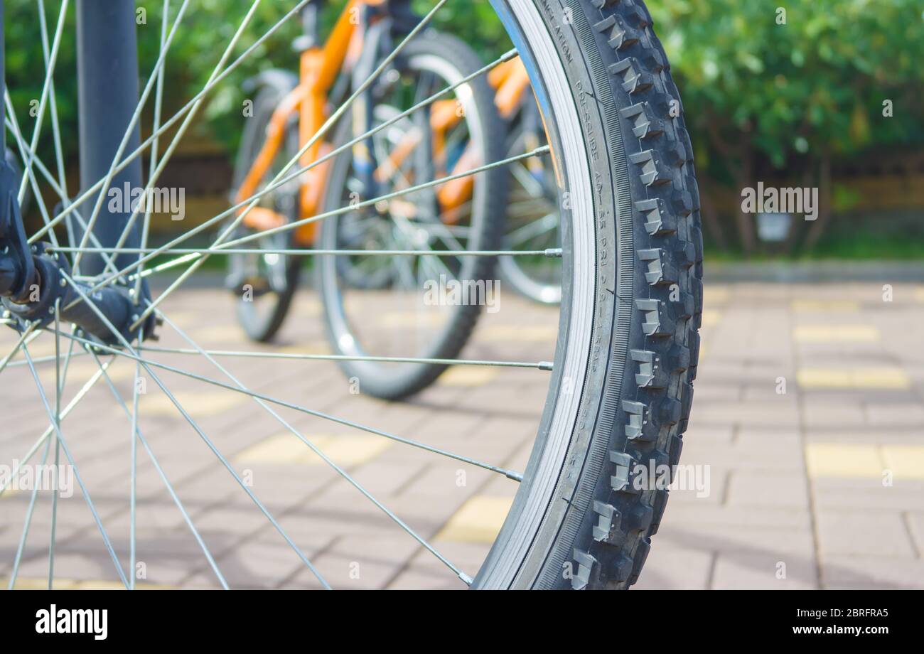 Bike wheel photographed close-up against a background two bikes. Stock Photo