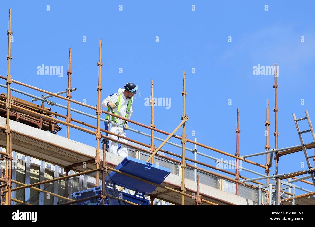 A construction worker wears a face shield on a construction site in