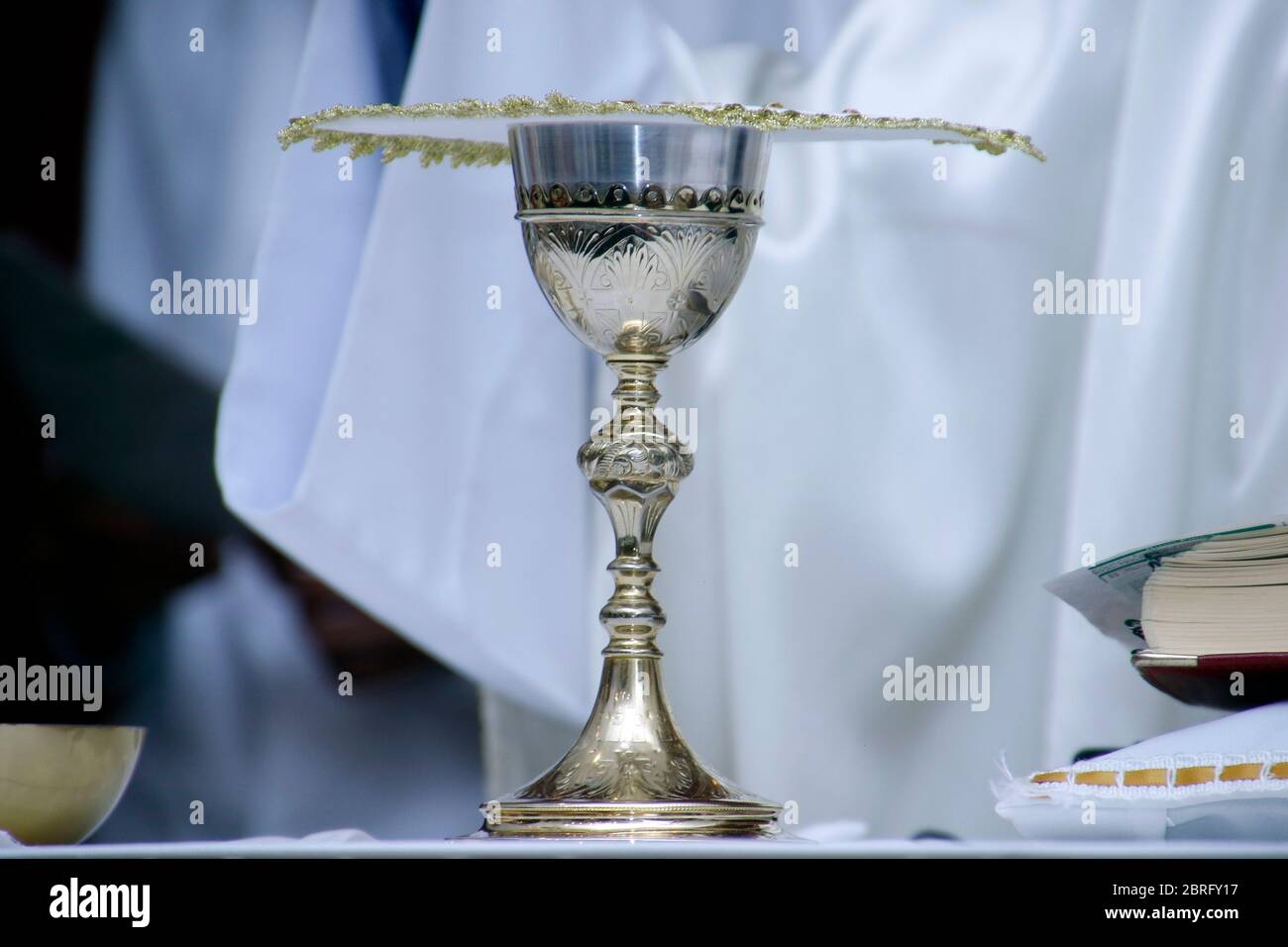 Holy Wafer. Holy communion in church. Taking holy Communion. Priest celebrate mass at the church. Cup of glass with red wine, bread. Feast of Corpus C Stock Photo