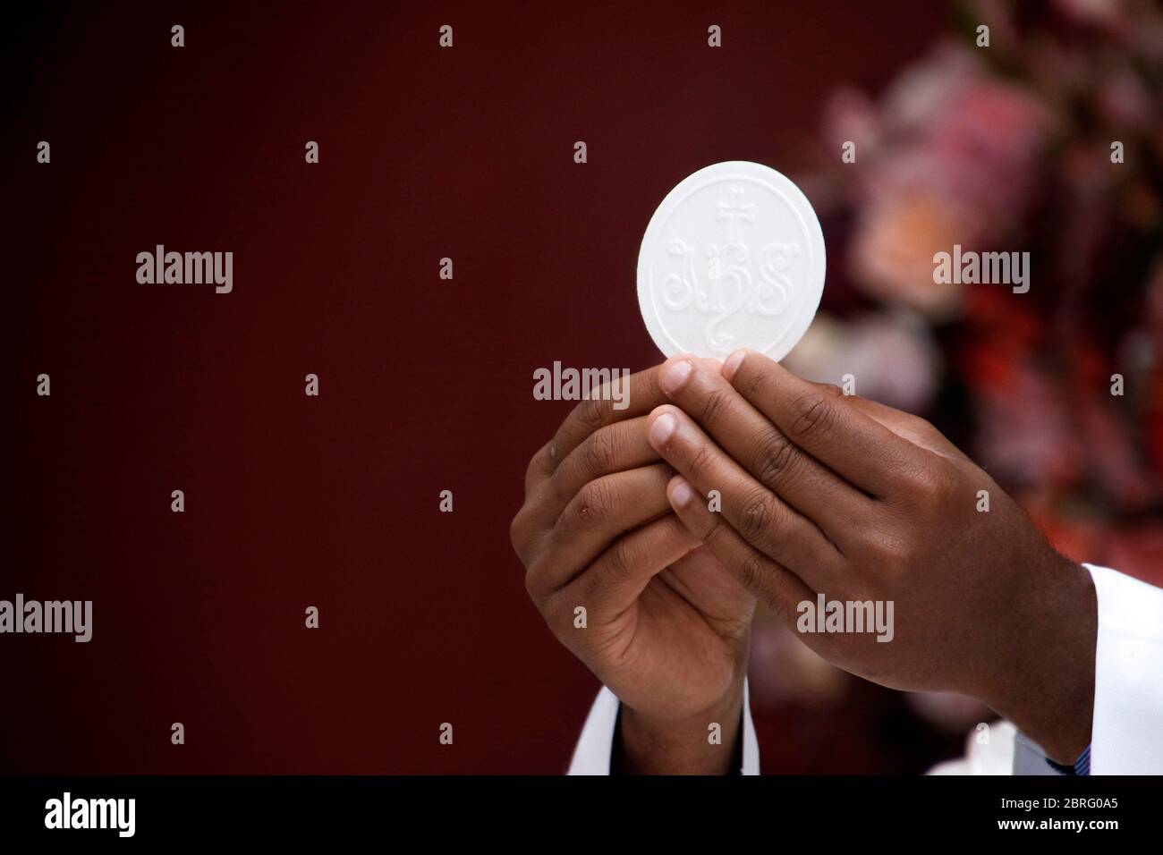 Holy Wafer. Holy communion in church. Taking holy Communion. Priest celebrate mass at the church. Cup of glass with red wine, bread. Feast of Corpus C Stock Photo