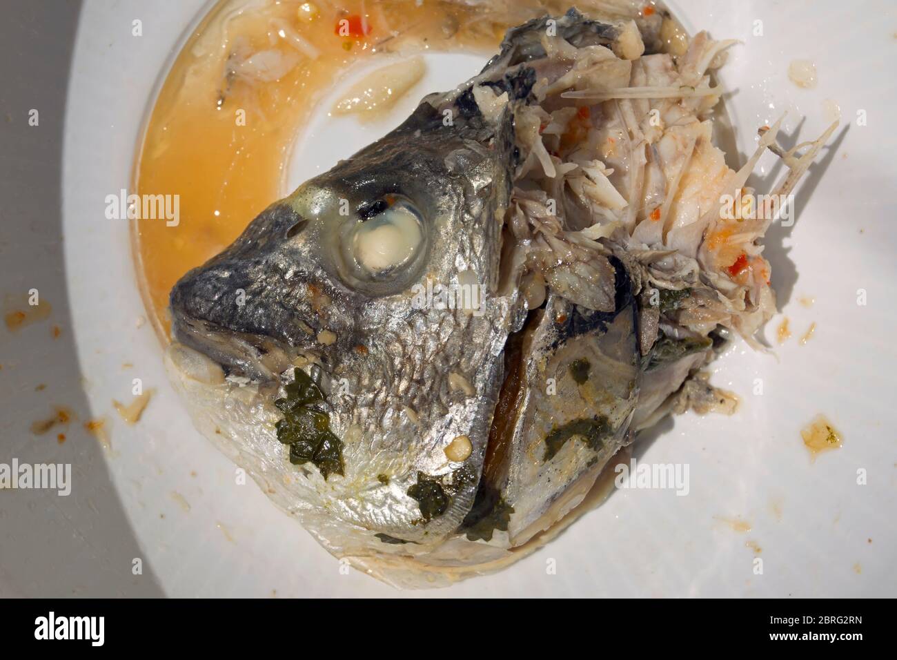 remains after being eaten of a thai-style tom yam fish head soup dish Stock Photo