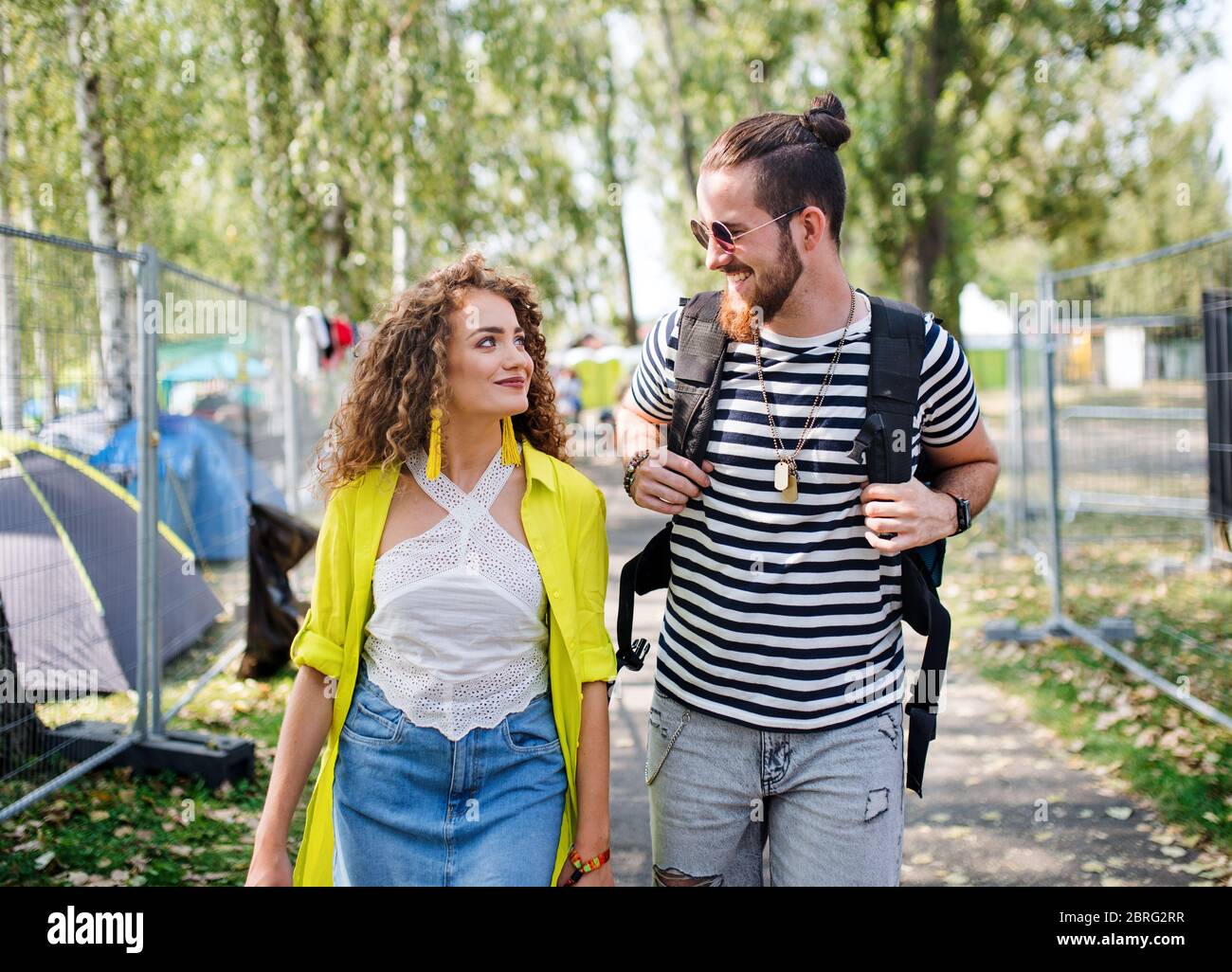 Young couple at summer festival or camping holiday, walking. Stock Photo