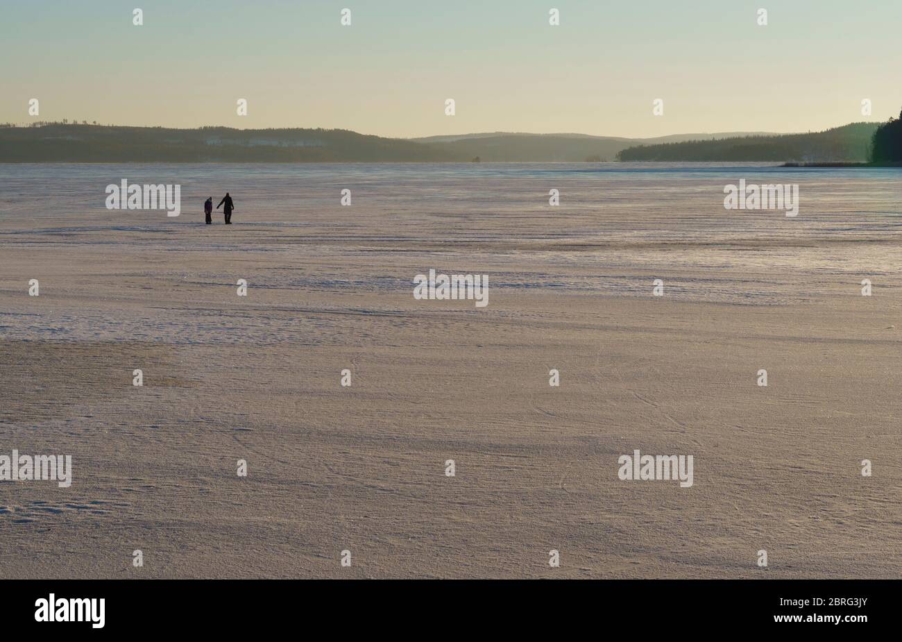 Man and woman walking on ice at frozen Lake Päijänne at Winter , Finland Stock Photo