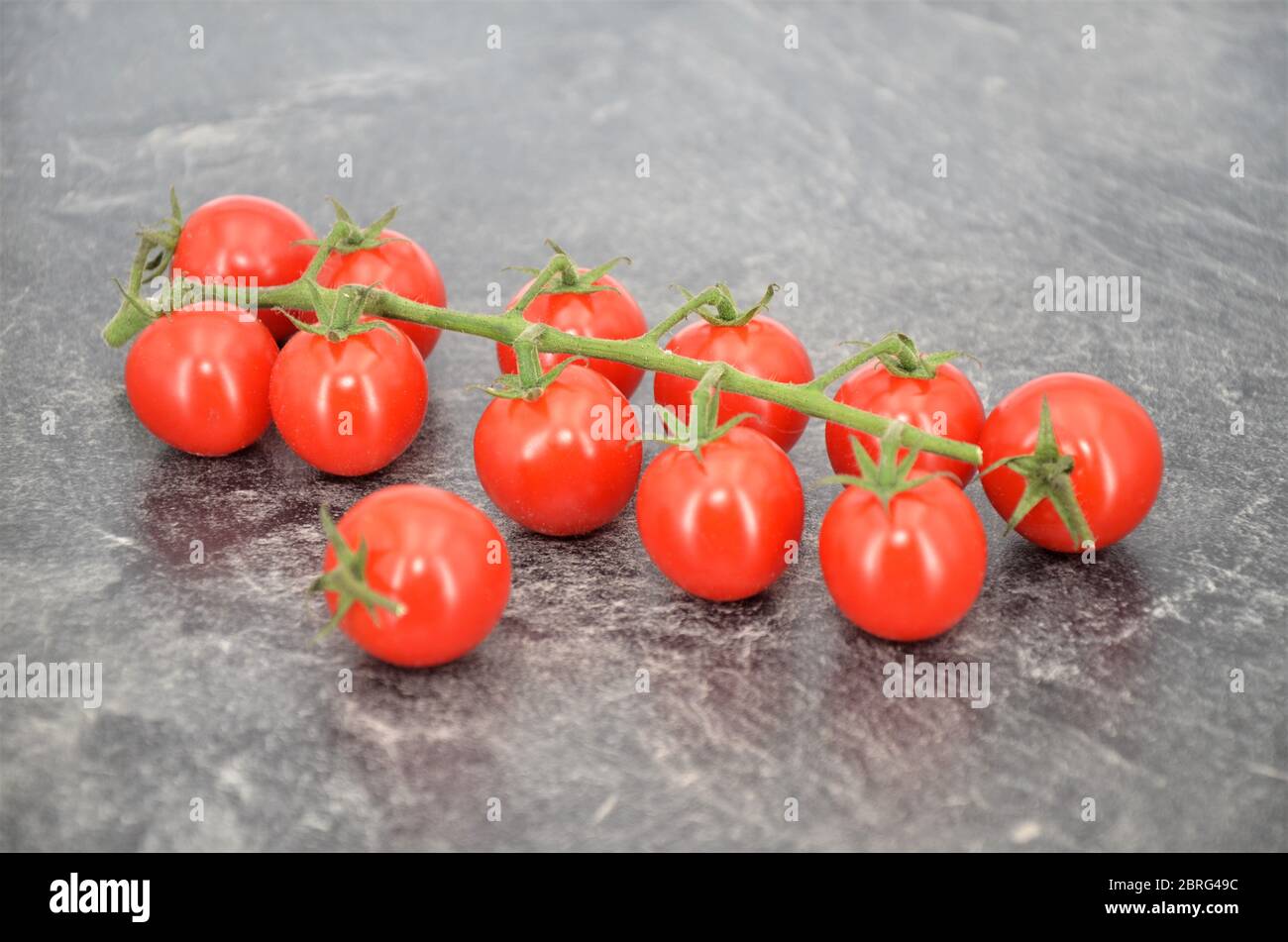 cherry tomatoes on kitchen table Stock Photo - Alamy