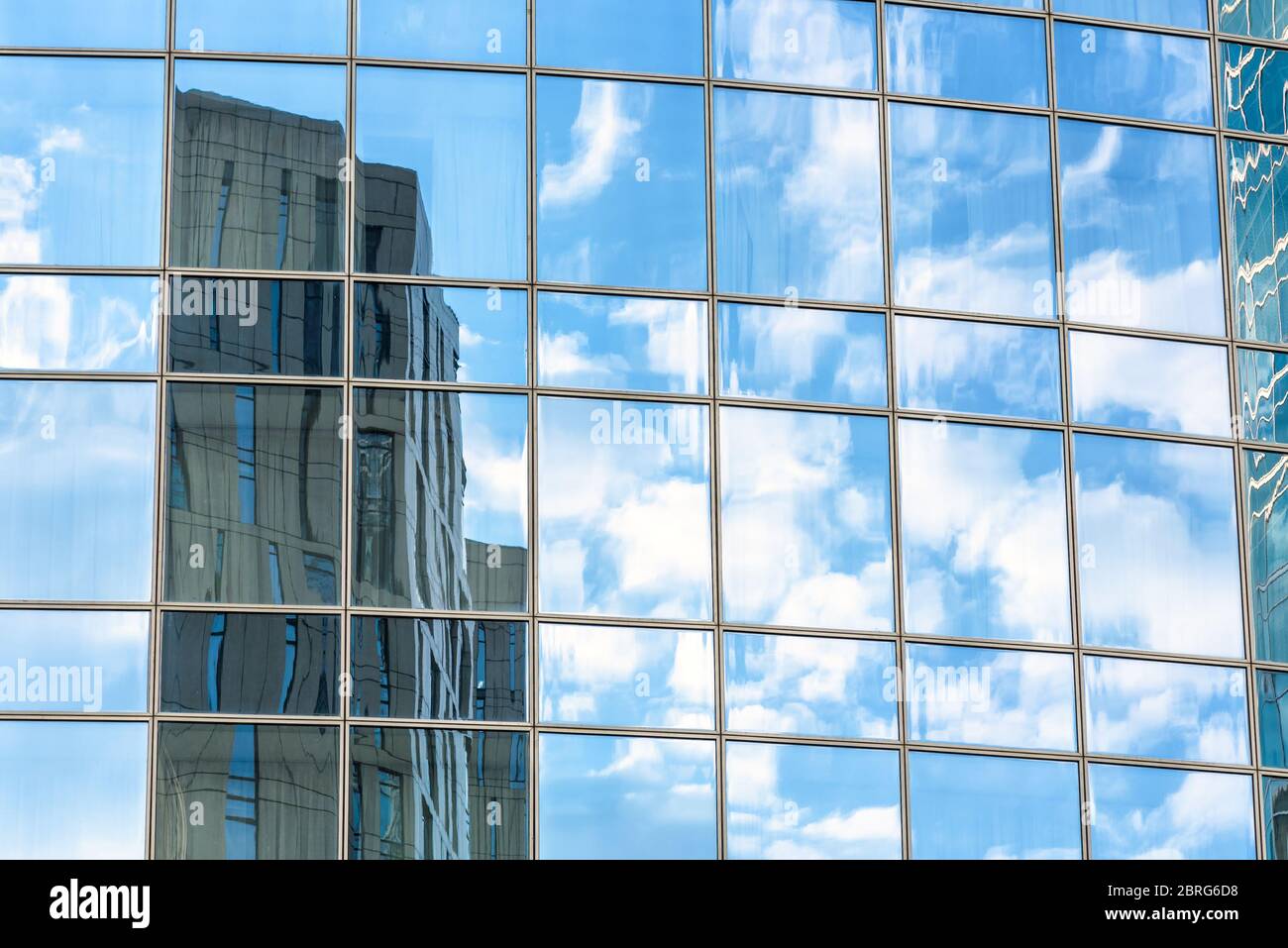 Abstract architecture background. Sky and buildings are reflected in the office skyscraper facade. Concept of modern urban constructions and business. Stock Photo