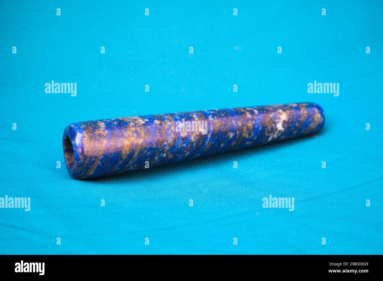 Clay chillum for marijuana smoking on a blue fabric background Stock Photo