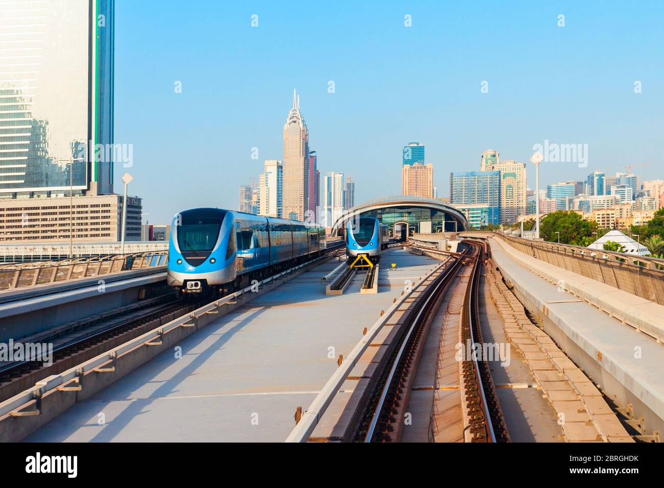 Dubai Metro train and Dubai city skyline in UAE Stock Photo