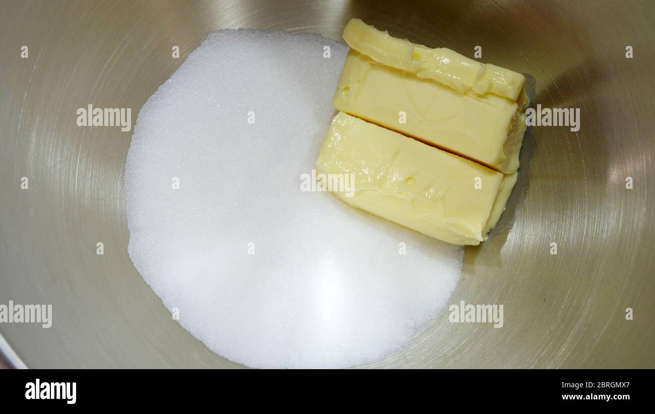 Closeup of chunks of butter and white sugar, in metal mixing bowl. Stock Photo