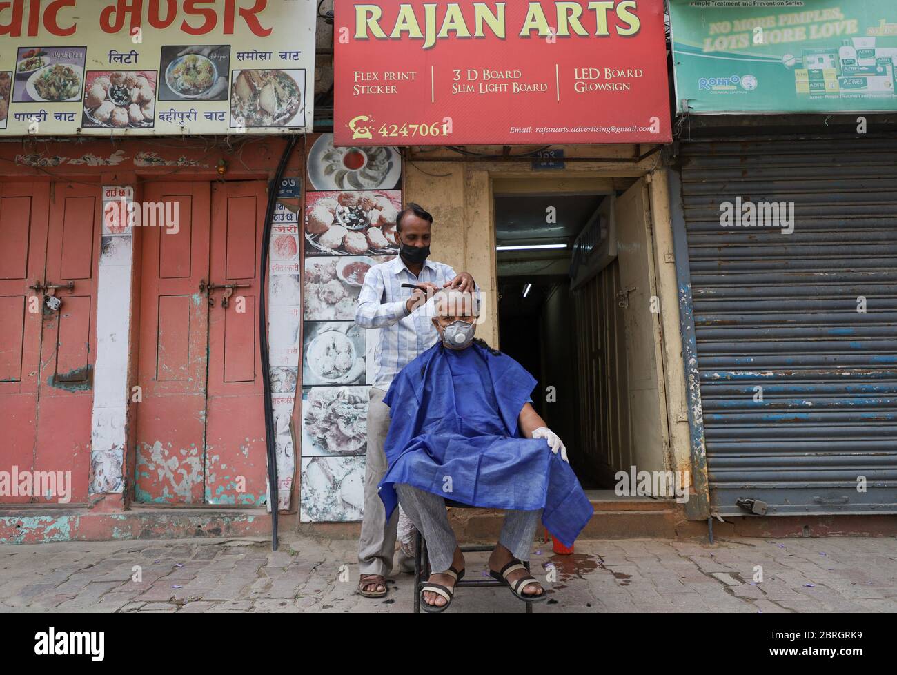 Kathmandu, Nepal. 21st May, 2020. A barber wearing face mask cuts the hair of a customer at a roadside during the nationwide lockdown in Kathmandu (Photo by Subash Shrestha/Pacific Press) Credit: Pacific Kathmandu, Nepal. 21st May, 2020. A barber wearing face mask cuts the hair of a customer at a roadside during the nationwide lockdown in Kathmandu (Photo by Subash Shrestha/Pacific Press) Credit: Pacific