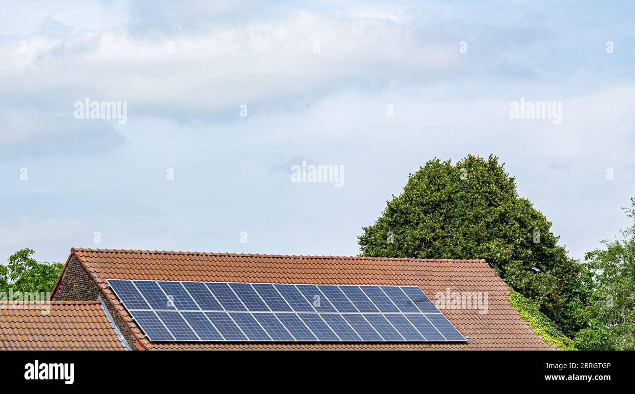 Energy, technology, electricity and ecological concept: solar panels on a house roof as a source of clean renewable energy. Stock Photo