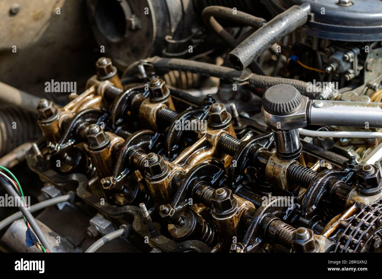 The engine compartment of a passenger car closeup. Tightening the cylinder head. Manual