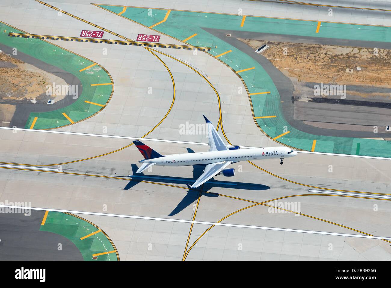 Delta Airlines Boeing 757 departing LAX International Airport. Aerial view of airplane taking off with airport taxiway lines below. 757-300 N588NW. Stock Photo