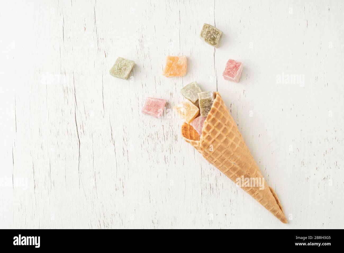 colorful turkish delights in an ice cream cone on a white wooden table ...