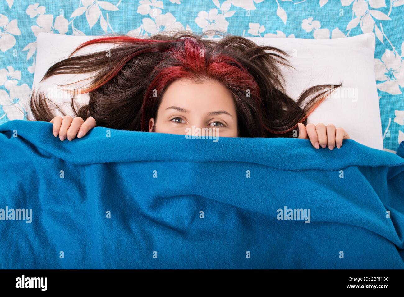 Good morning you... Beautiful young girl lying in bed, hiding her face