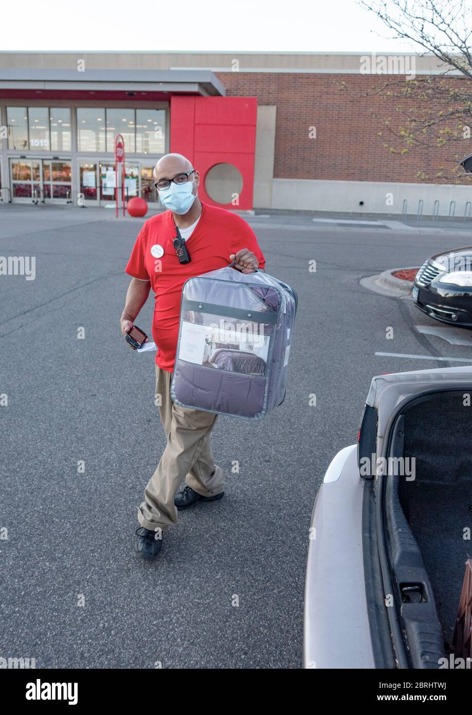 Masked Target worker delivering online purchase to the car in the pick-up area during the CORONA-19 pandemic. Roseville Minnesota MN USA Stock Photo