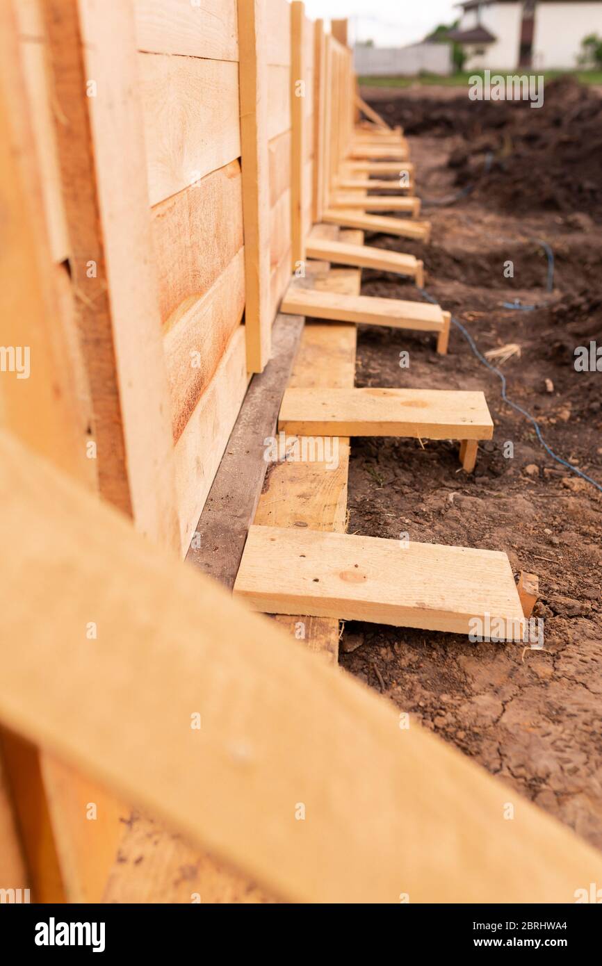 Wooden formwork for creating strip foundation for new house basis. Constructing house from the beginning concept Stock Photo