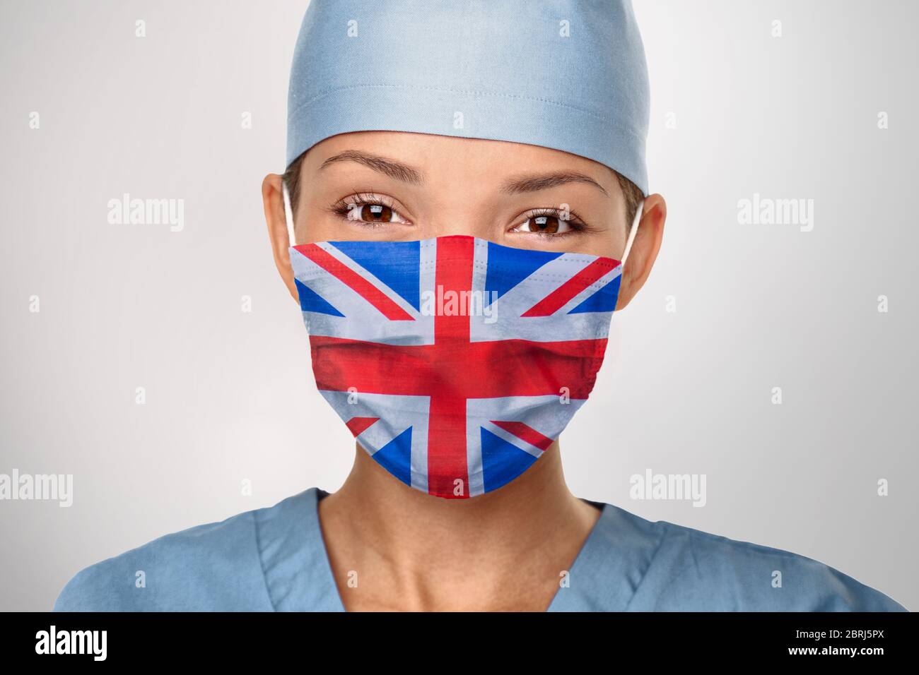 UK flag on british doctor nurse woman wearing face mask. United Kingdom flag print graphic design. Asian medical professional. Stock Photo