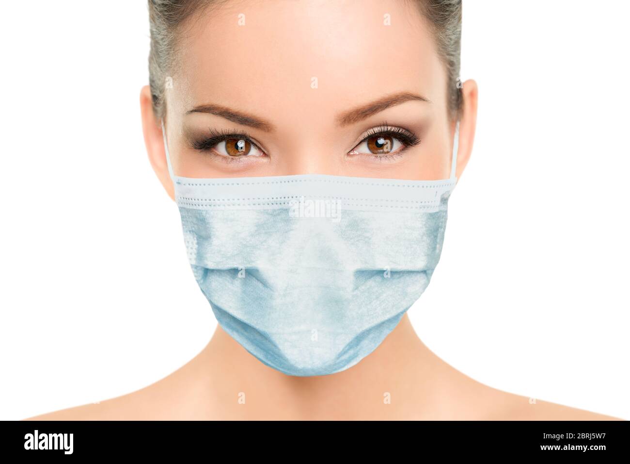 Beautiful Asian woman wearing medical face mask with eyes makeup beauty model portrait isolated on white background for Coronavirus. Stock Photo
