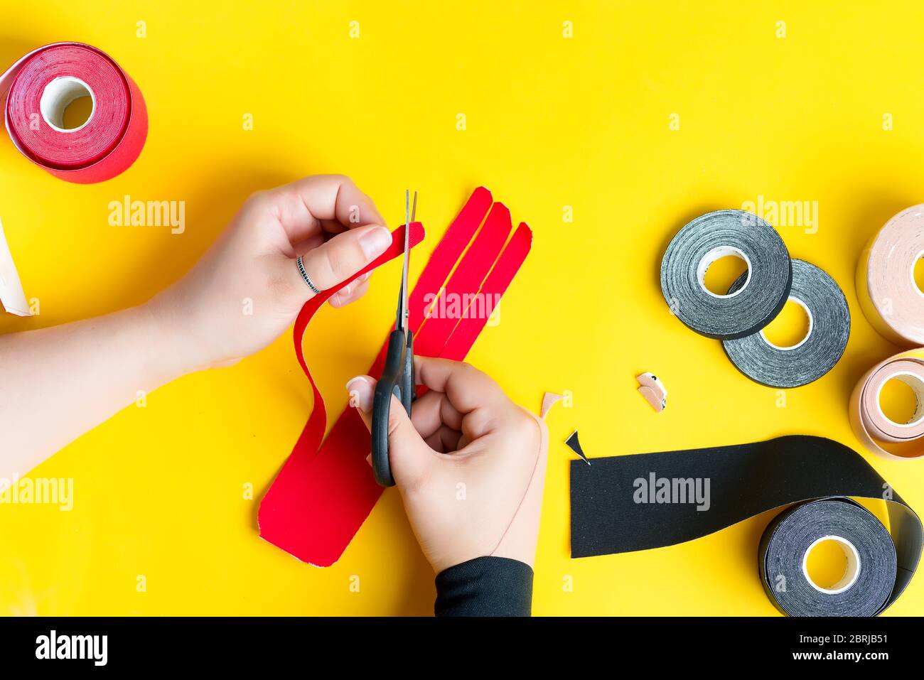 Kinesiology taping treatment. Step by step process of cutting red tape