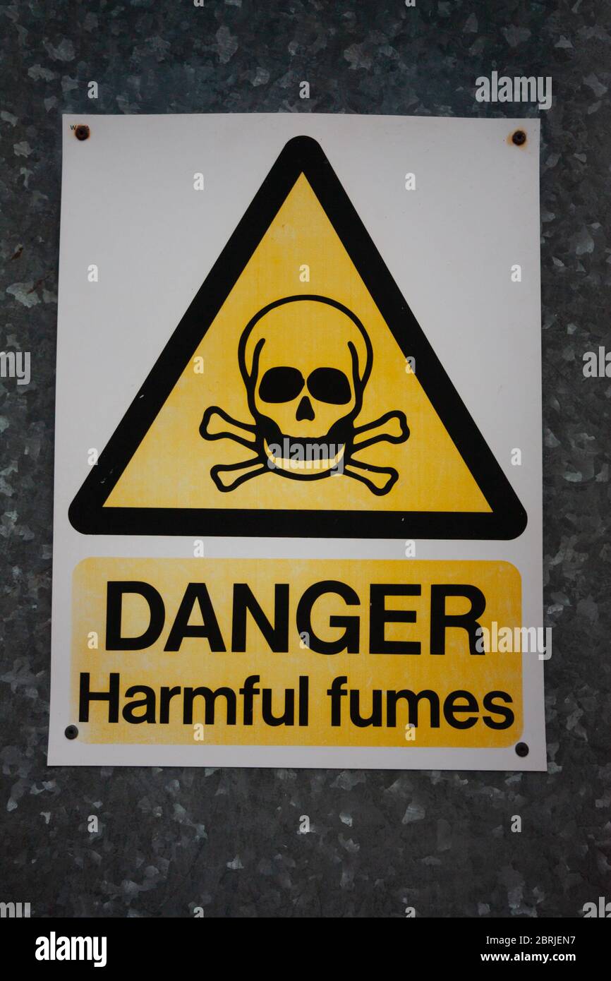 Danger harmful fumes yellow sign skull and crossbones in old power station Stock Photo