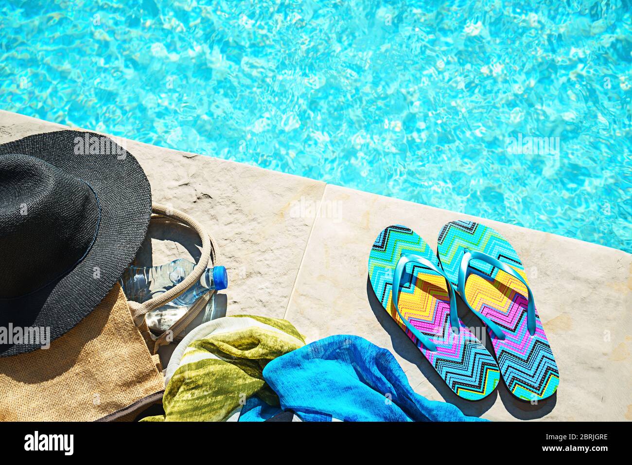 Swimming pool and straw hat, colorful flip flops, wicker bag, straw hat ...
