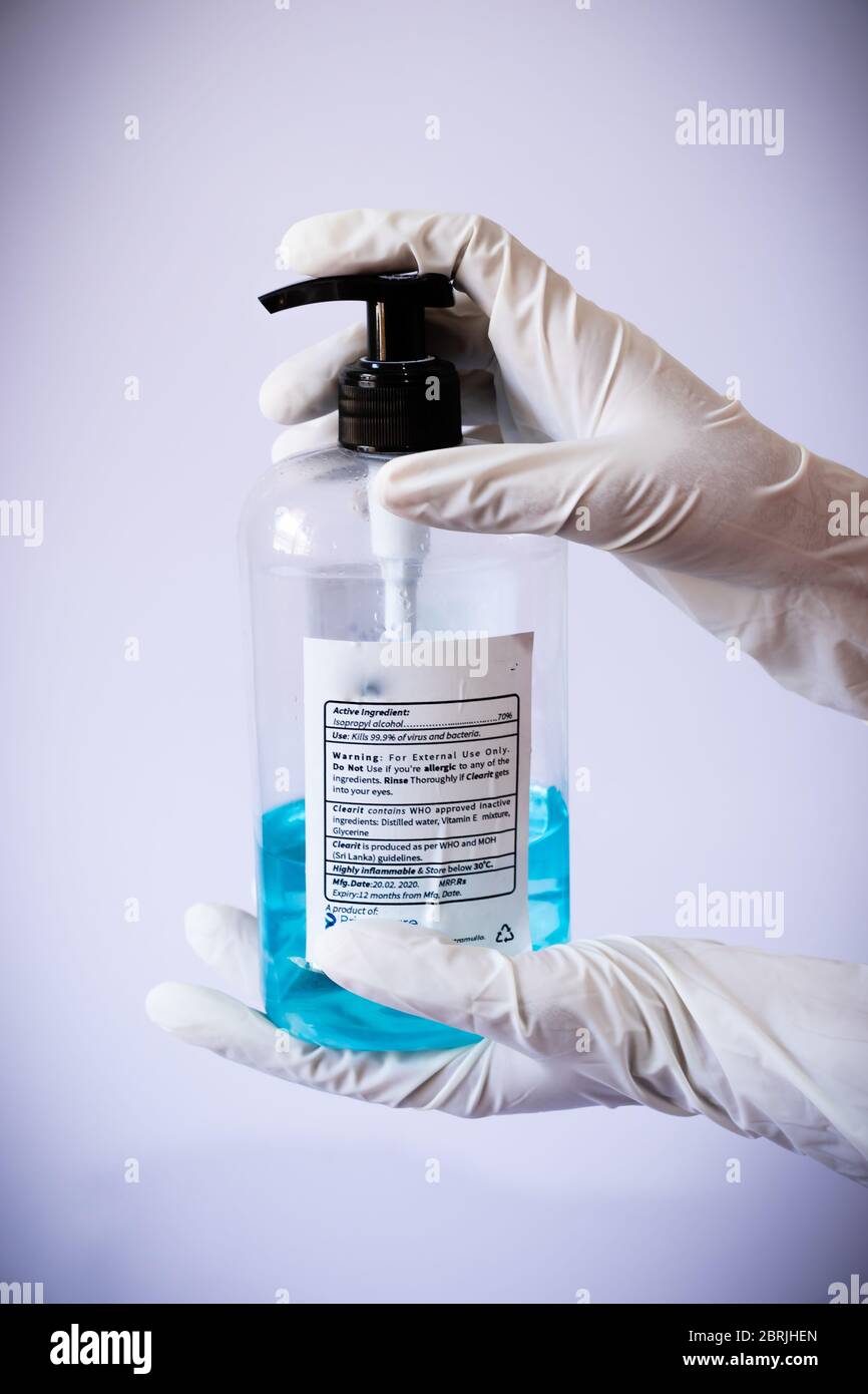 Presenting sanitizer bottle by both hands with medical latex gloves
