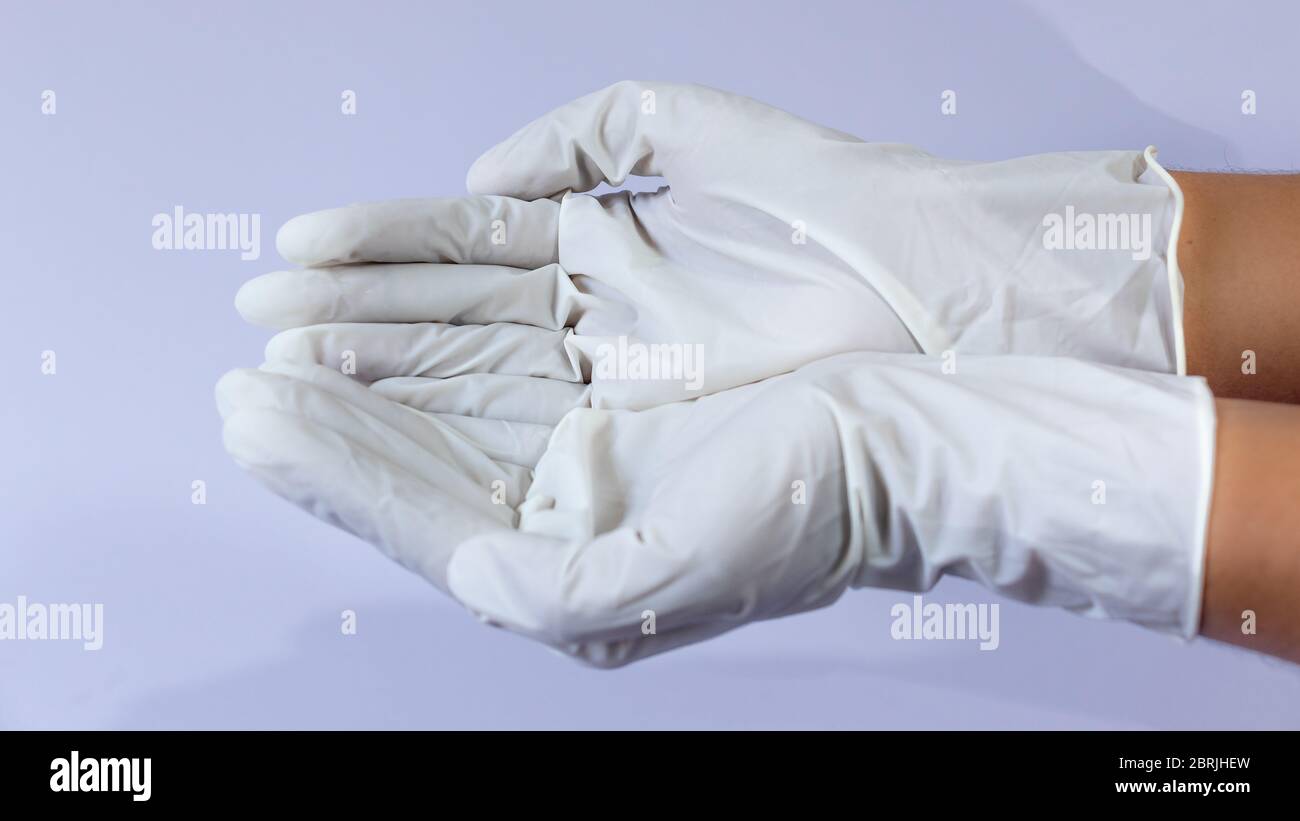 Female doctor wearing medical latex gloves in both hands together Stock Photo