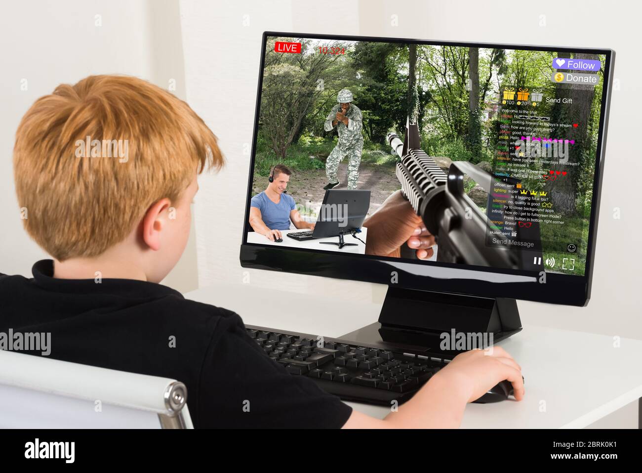 Kid Watching Live Game Streaming Session On Desktop Computer Stock Photo
