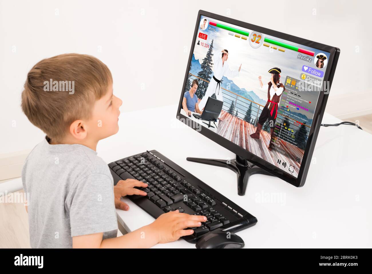 Kid Watching Live Game Streaming Session On Desktop Computer Stock Photo