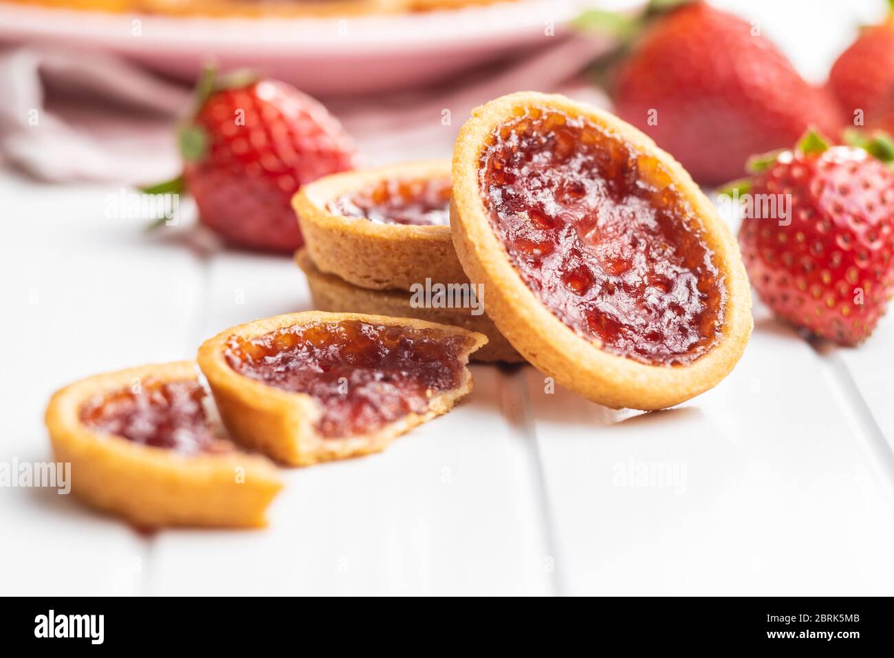Sweet biscuits with strawberries jam and strawberries on white table. Stock Photo