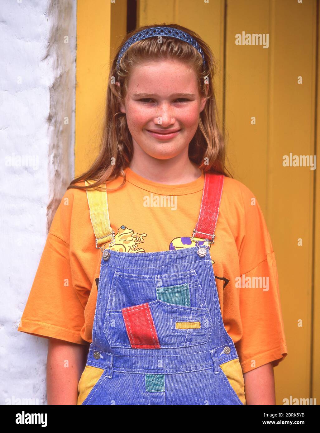Young smiling Irish girl outside farmhouse, Ulster Folk & Transport Museum, County Down, Northern Ireland, United Kingdom Stock Photo