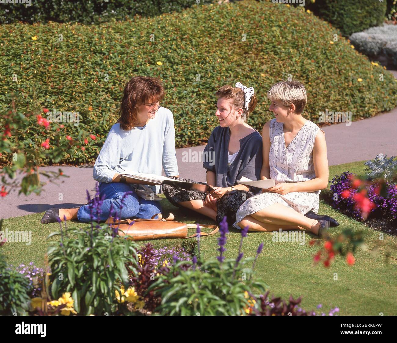 Young female students sitting in grounds of Guildford Castle,  Guildford, Surrey, England, United Kingdom Stock Photo