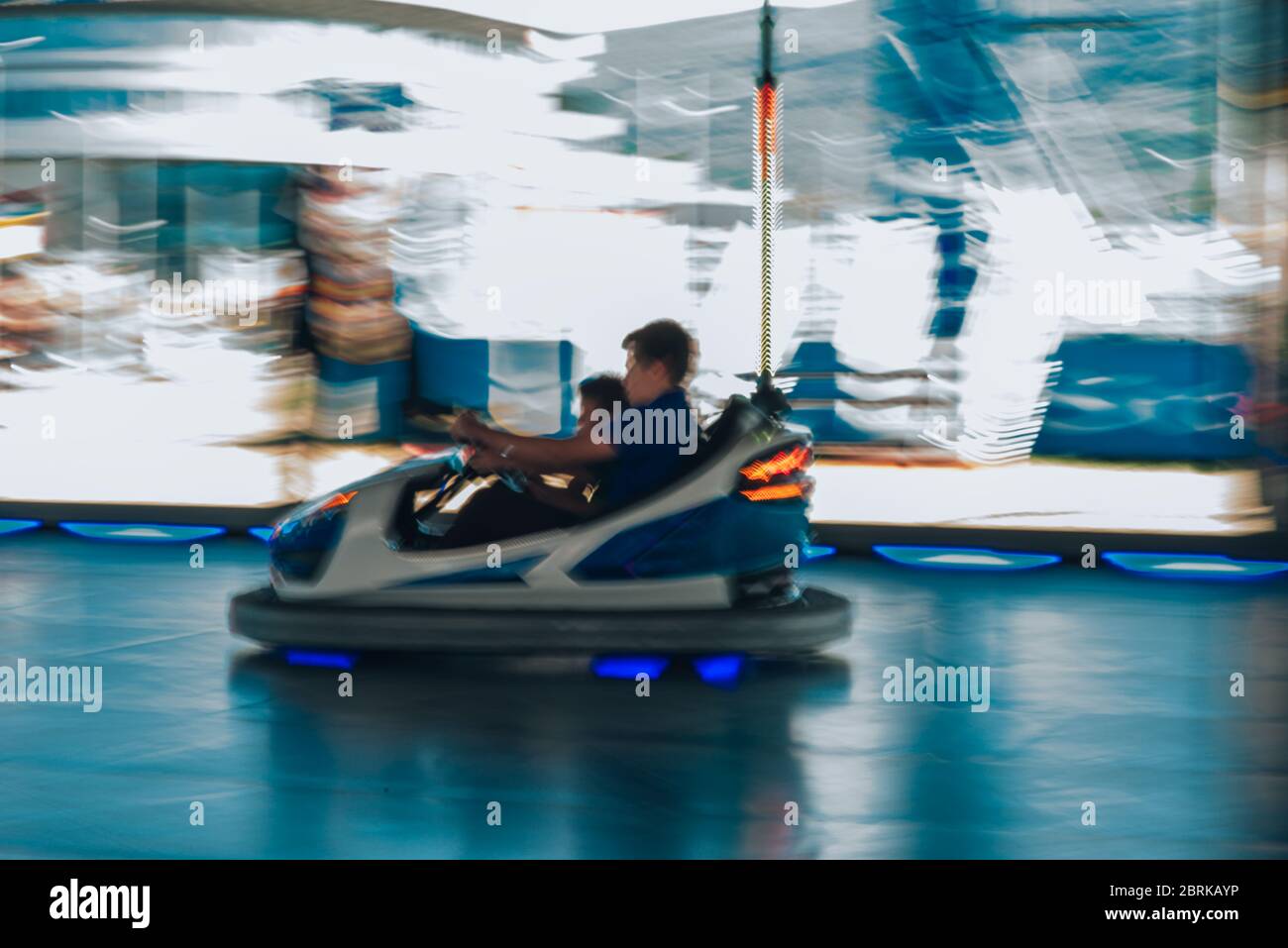 Two kids having fun while riding bumper car on a carnival Stock Photo