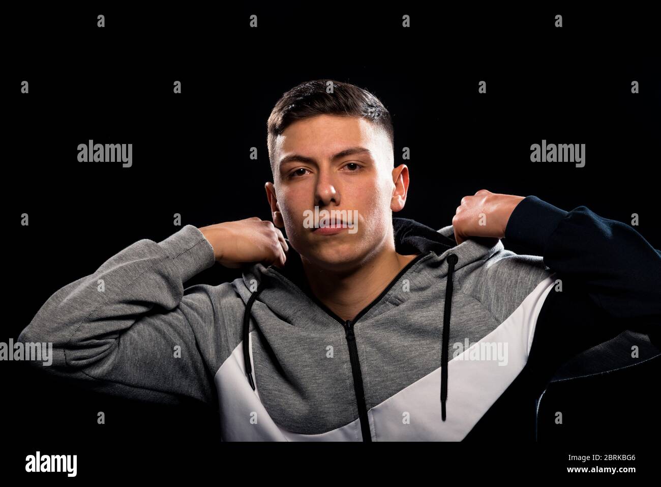 Young casual man wearing tracksuit standing over black background Stock Photo