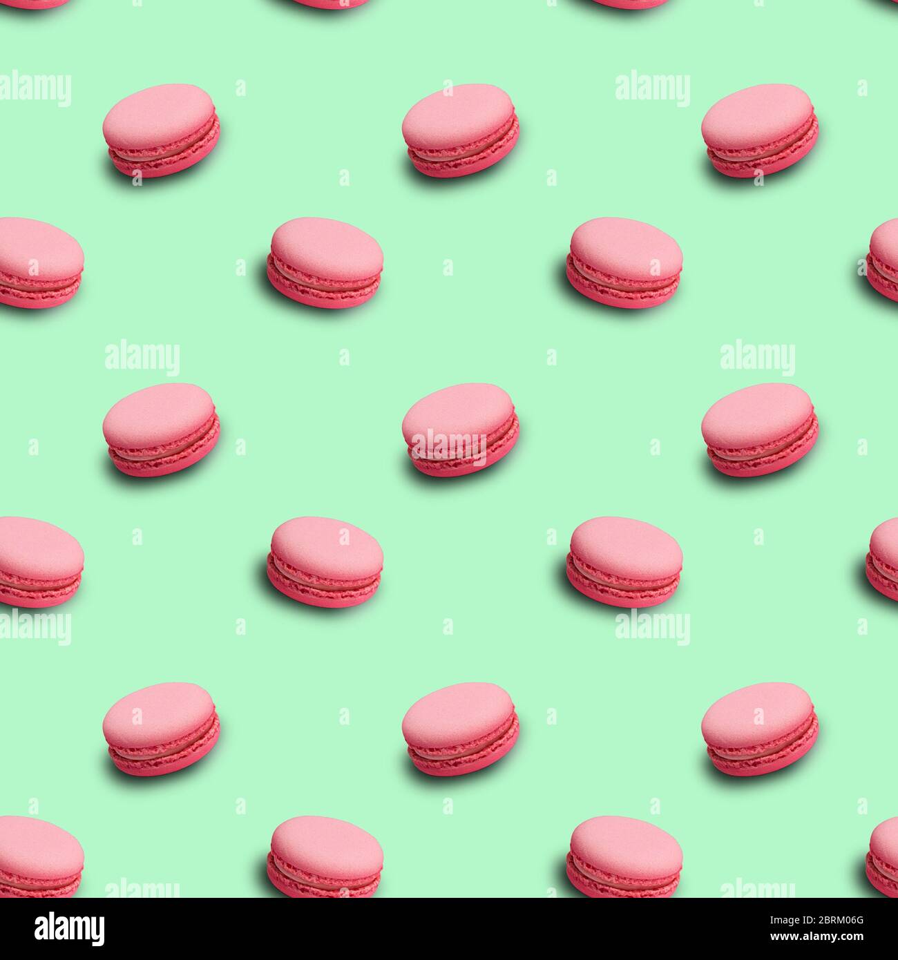 Pastel color seamless pattern with french pink macarons on mint background Stock Photo