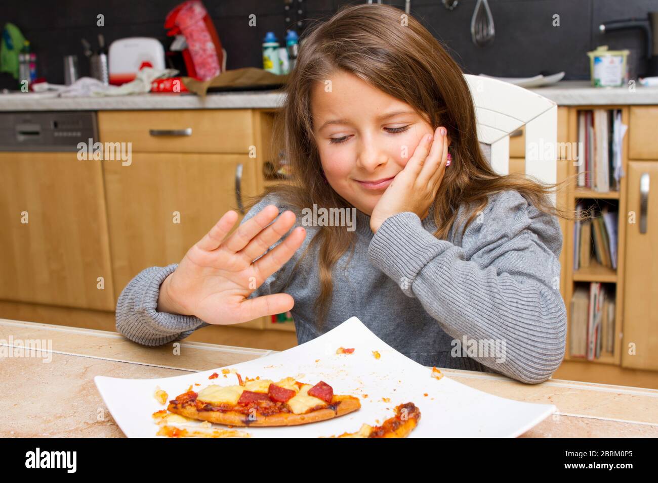 Kind vor Teller mit Pizzaresten, MR: Yes Stock Photo