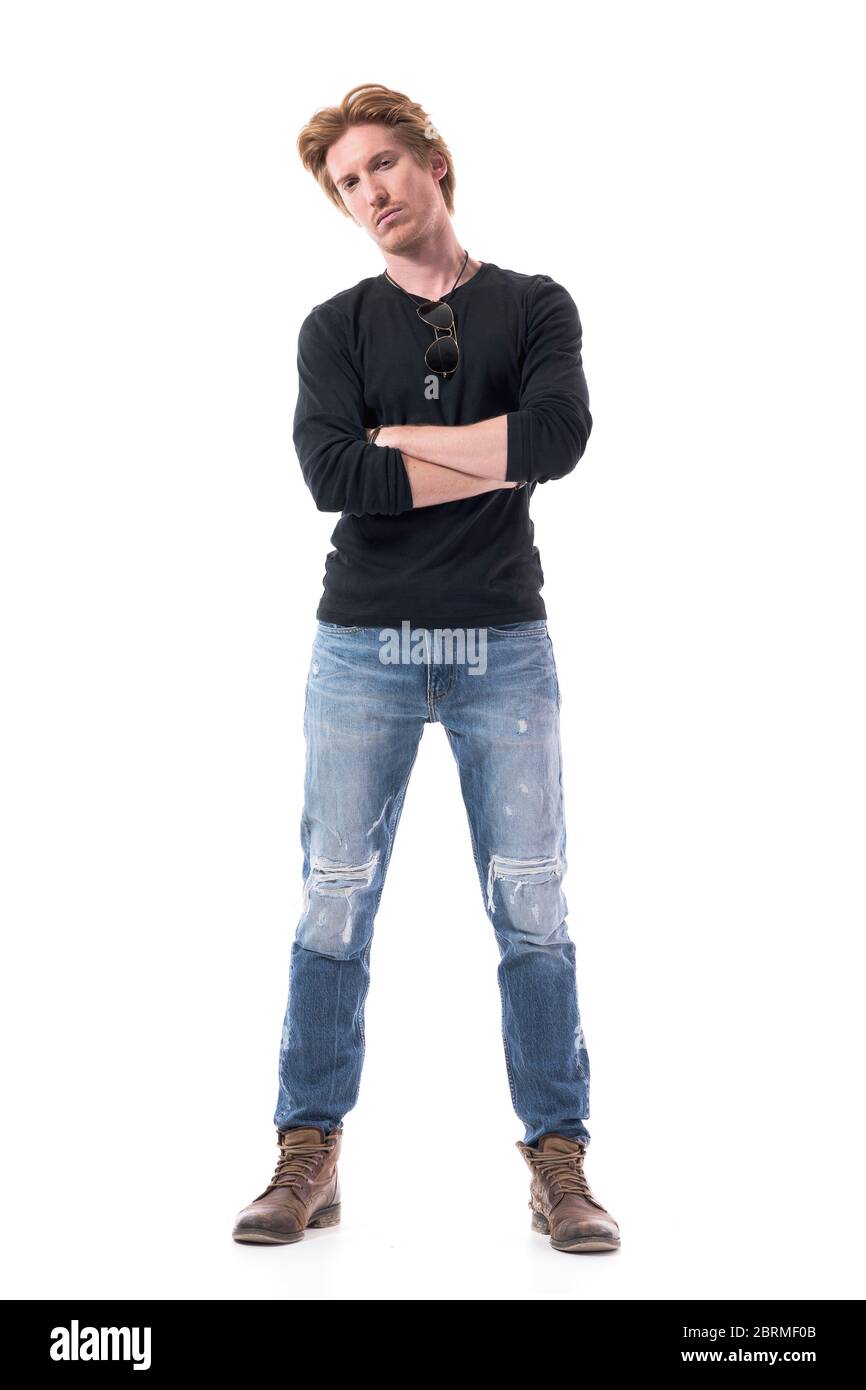 Suspicious distrustful young man with crossed hands looking at camera doubtfully and skeptically. Full body length isolated on white background. Stock Photo
