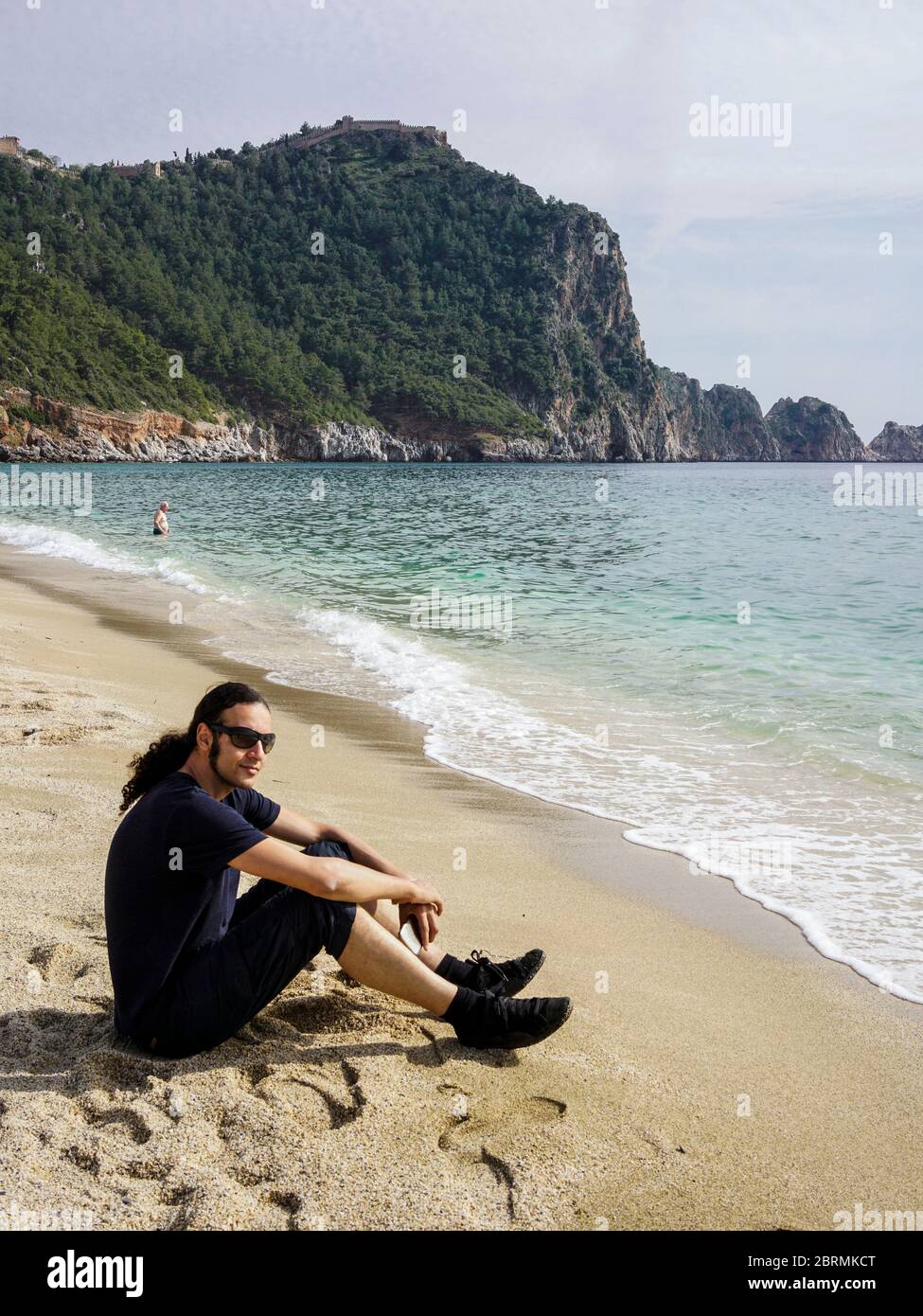 Young man sitting by the cleopatra beach and relaxing Stock Photo