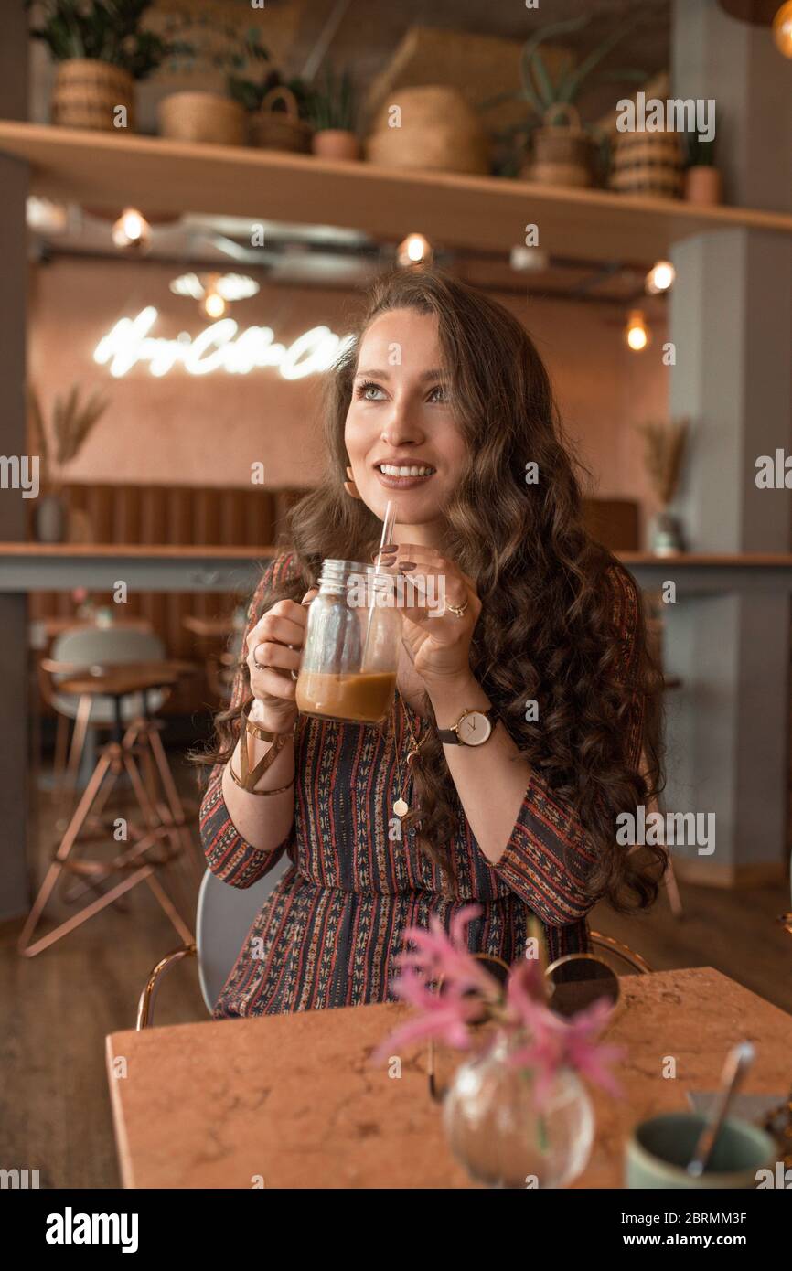 Young beautiful woman enjoying her coffee at coffee shop Stock Photo