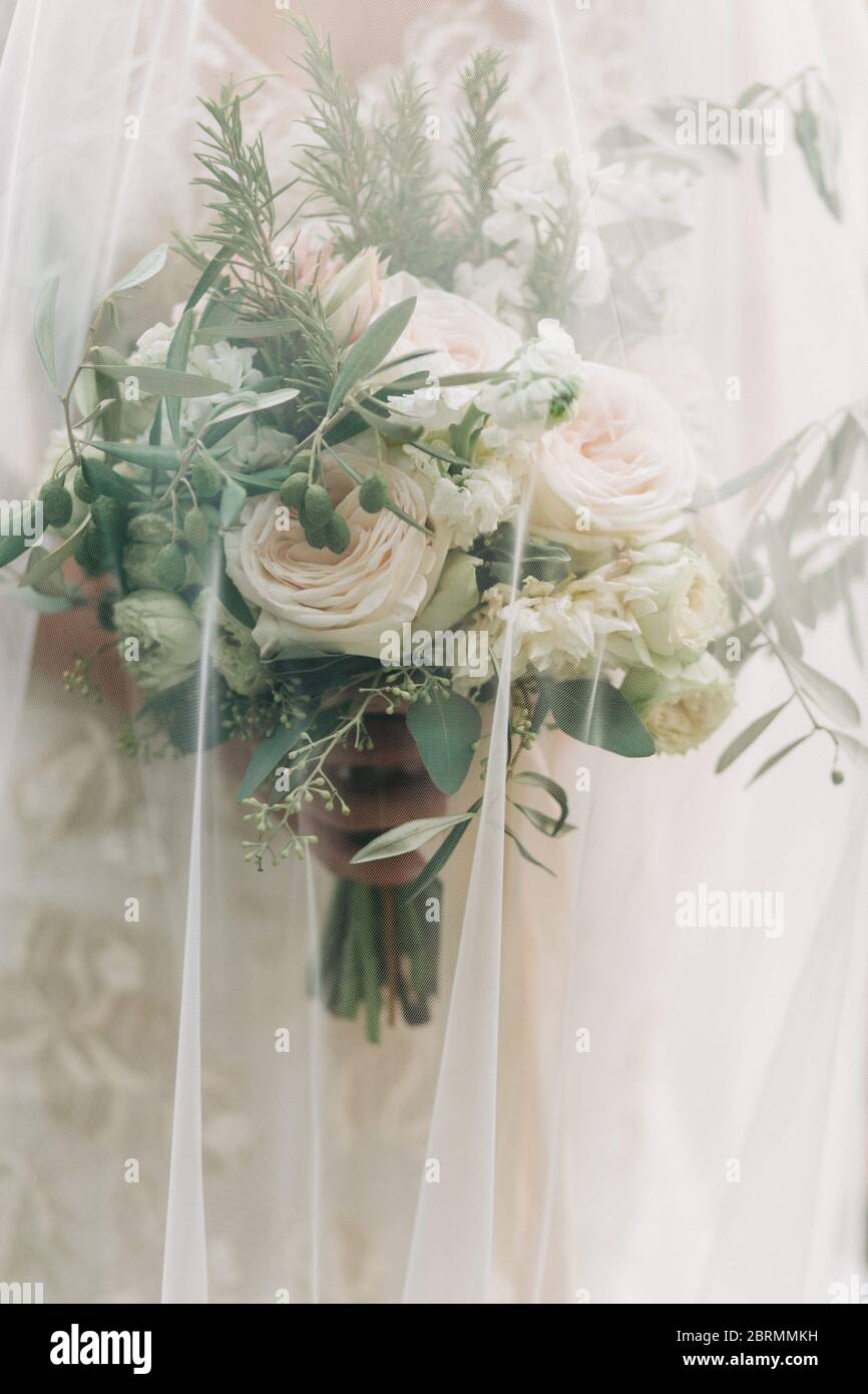 Bride keeping her wedding bouquet under her veil Stock Photo Alamy