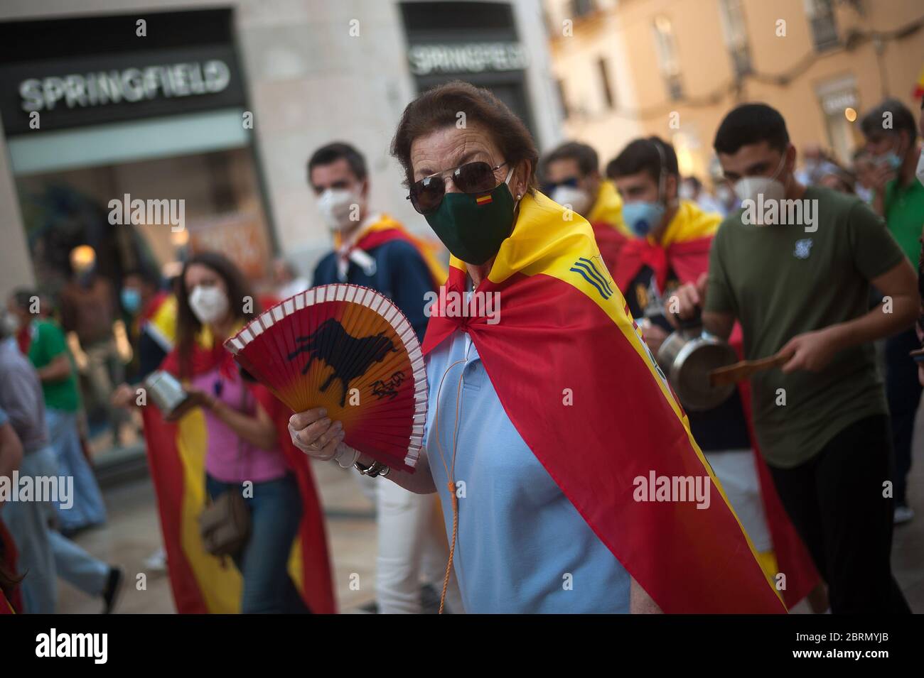 A woman wrapped with a Spanish flag takes part during the demonstration.Several Spaniards have protested against the Spanish government and public management of the Covid - 19 crisis. The far-right party VOX demand the end of confinement and state of emergency because they consider that limit their rights and all Spaniards. Stock Photo