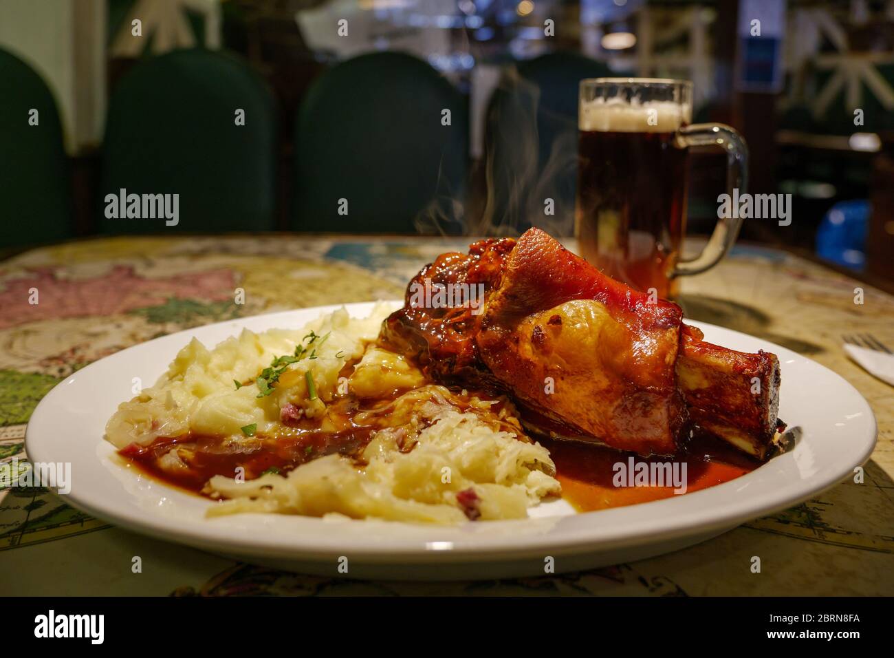 Pig knuckles with old dark beer sauce, roast potatoes and cabbage salad