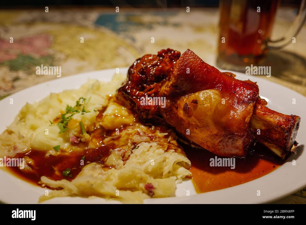 Pig knuckles with old dark beer sauce, roast potatoes and cabbage salad