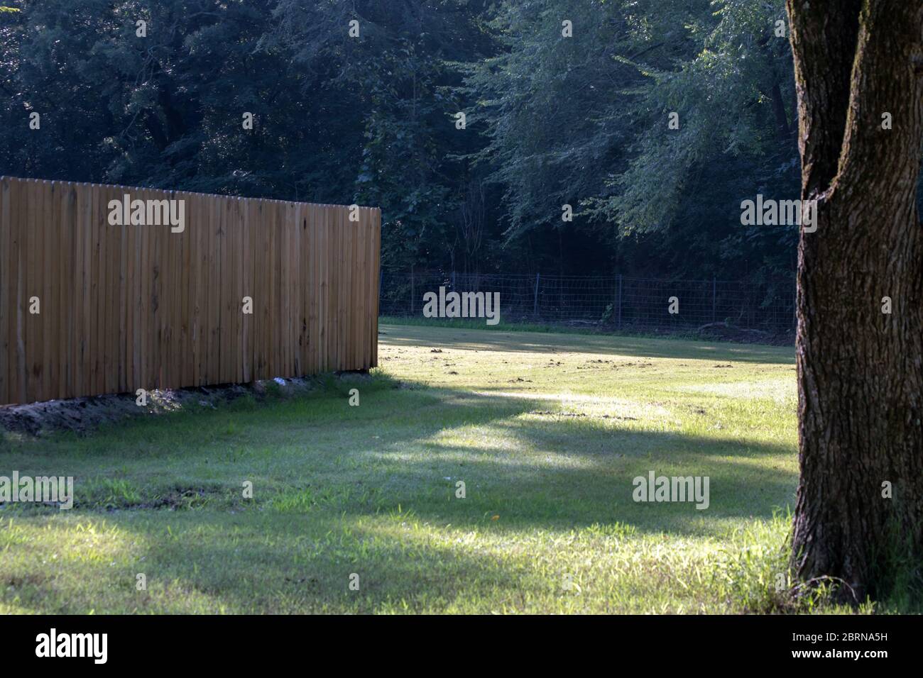 A wooden privacy fence indicates boundary lines at this pretty little Mississippi park. Bokeh. Stock Photo