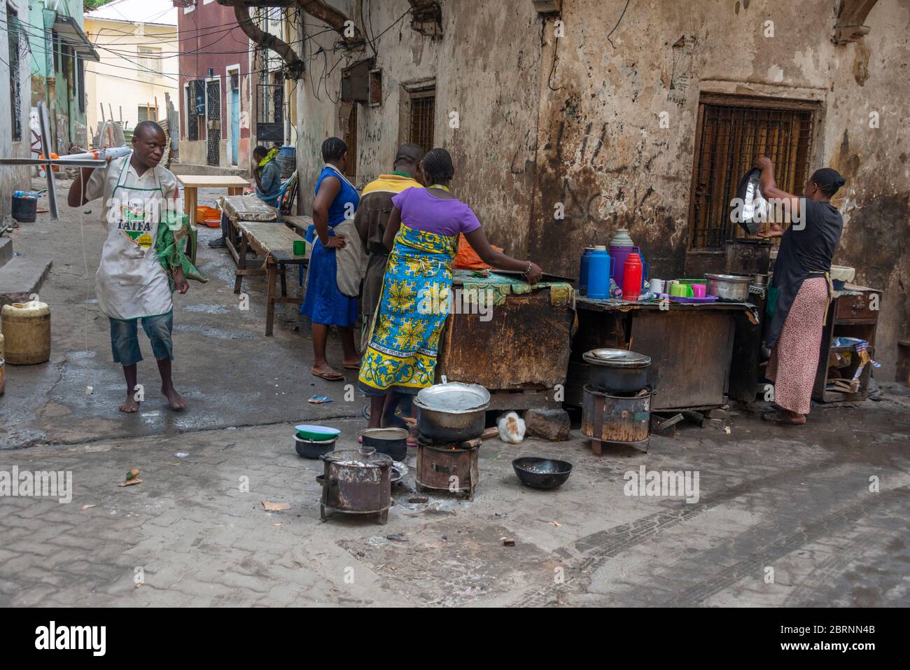 Street scene in Old Town Mombasa with women preparing food for sale Stock Photo