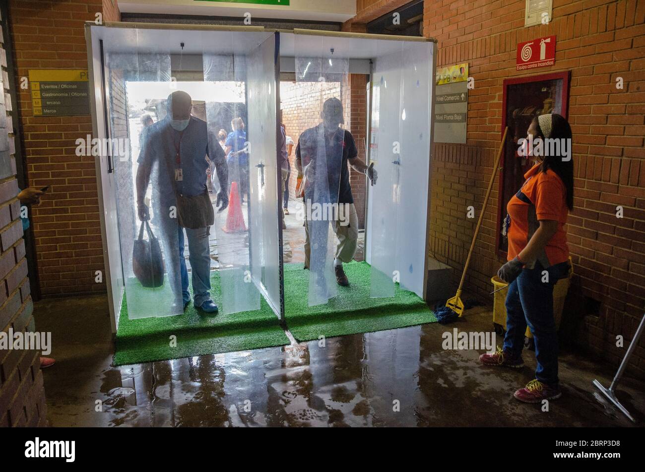 Users of the Municipal Market of Chacao, waiting in line to use the disinfection booth to enter the facility, to prevent the spread and infection of C Stock Photo