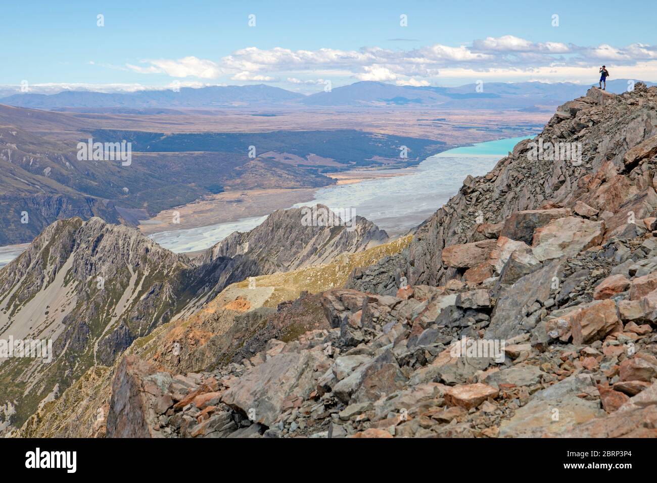 Person on the summit of Mt Ollivier, looking out to Lake Pukaki Stock Photo