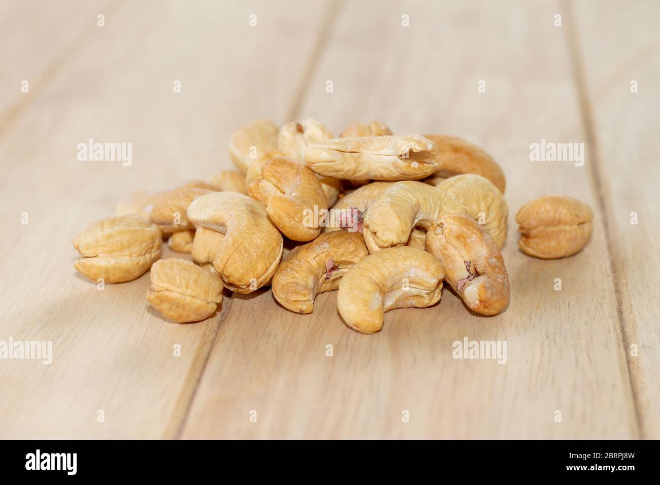 Many Roasted salted cashew nuts  on wooden background Stock Photo
